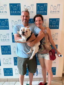 Couple with newly-adopted dog pose by Dakin's front door