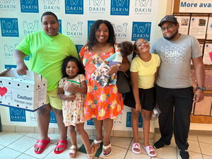 Family pictured with newly-adopted cat (in carrier) at Dakin Humane Society