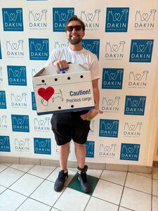 Man happily holds up his newly adopted cat (in carrier) before leaving Dakin's adoption event