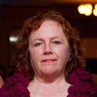 A woman in a red top smiling at the camera